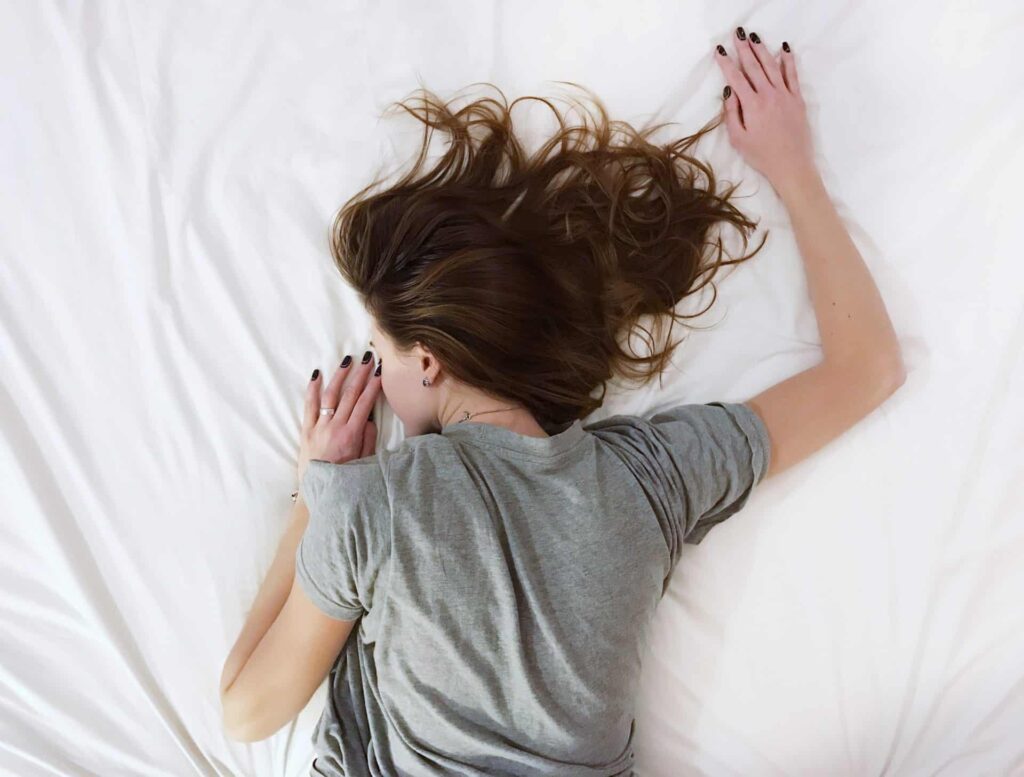 Vrouw ligt vermoeid in bed