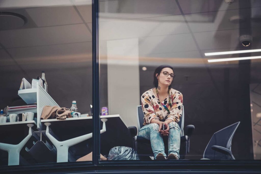 Vrouw met bore-out staart op kantoor uit het raam
